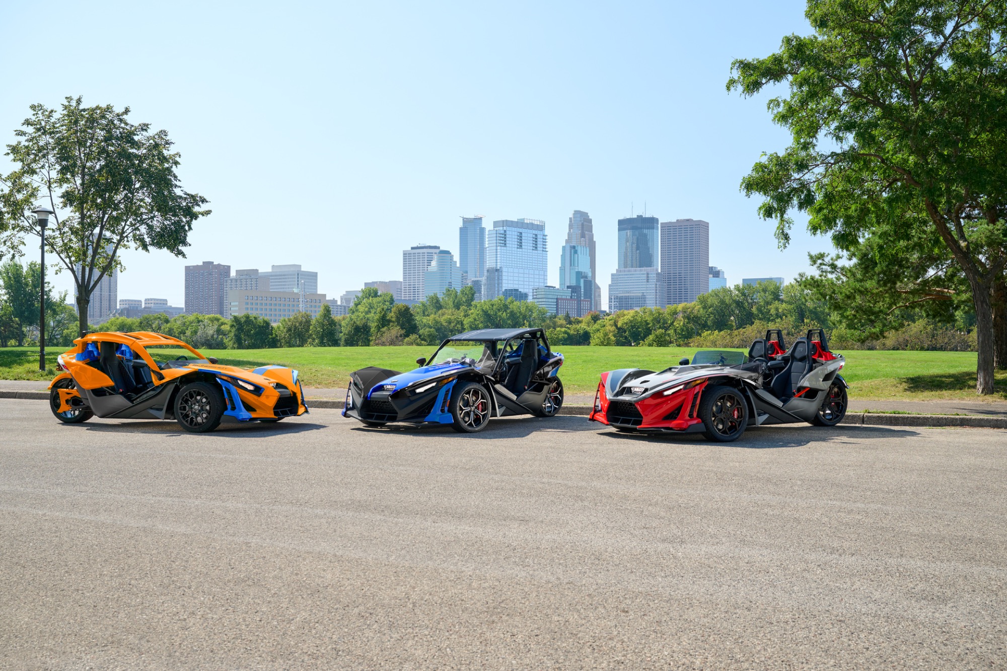Polaris Slingshot lineup with a city skyline backdrop