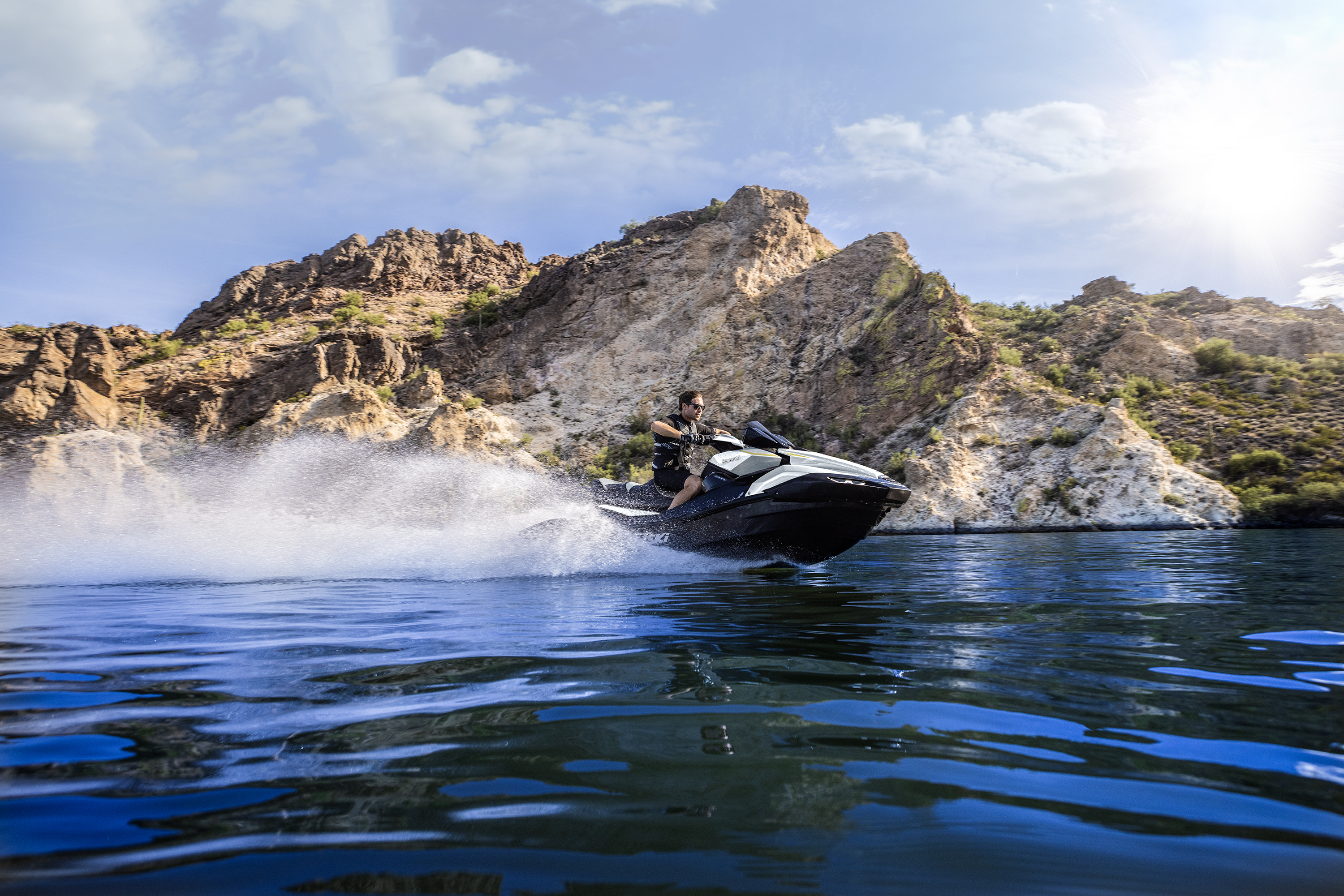 Rider carving along a lake cove on a personal watercraft